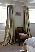 Silk curtains in bedroom with chair