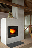 Lit fire in stove in contemporary country style room