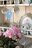 Pink flowers and chinaware with wall shelf