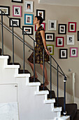 Family photographs on staircase in home of London fashion designer