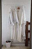 White dressing gowns and laundry bags with wooden clothes airer