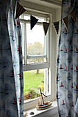 Toy boat on bedroom windowsill in Norfolk beach house, UK