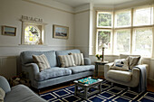 Light blue sofa and cream armchair in Norfolk beach house, UK