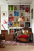 Vintage leather armchair in front of box shelves filled with books and memorabilia