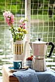 Espressokanne und Schnittblumen in Kaffeekanne auf Hausboot in Richmond upon Thames, London, UK