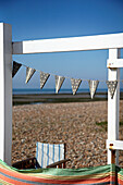 Deckchair and windbreak on shingle beach West Sussex, England, UK