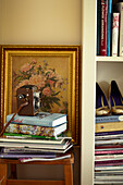 Bücher, Zeitschriften, Schuhe und ein Blumengemälde in einem Haus in Lincolnshire, England, UK