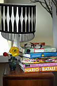 Lesebrille auf Bücherstapel daneben schwarze Lampe in einem Haus in Lincolnshire, England, UK