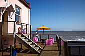 Woman on balcony terrace of Cromer beach house in Norfolk, UK