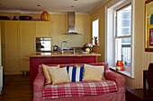 Gepunktete Kissen auf Sofa in offener Wohnküche in Cromer Strandhaus, Norfolk, England, UK