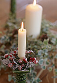 A detail of a lit candles decorated candlestick
