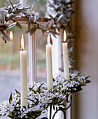 Weihnachtsdekoration aus Mistelzweig und brennenden Kerzen