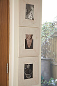 Close up detail of three framed photographs mounted one above the other on the wall