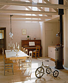 Country style dining room with a tricycle next to a large wooden dining table