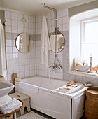 White bathroom with tiled walls and circular mirrors