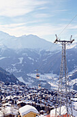 Ein Blick auf das Skigebiet von Verbier mit Seilbahnen, Chalets und schneebedeckten Bergen in der Ferne