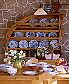 Country dining room with exposed stone walls and pine dresser with crockery display