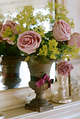 Arrangement aus rosa Blumen in einem Steinpokal