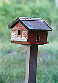 A detail of a rustic wooden bird house