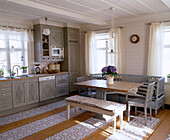 Traditionelle skandinavische Küche mit Einbauschränken und Tisch und Stühlen