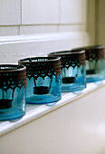 Blaue Glas-Teelichthalter auf einem Kaminsims