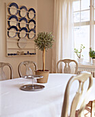 Dining table with Gustavian chairs and plate display rack on wall