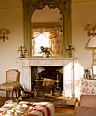 Mirror on mantlepiece above fireplace and hearth