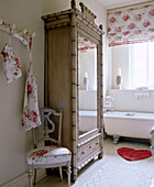 Verspiegelte Garderobe im Badezimmer mit geblümtem Stoff und herzförmigem Badvorleger