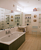 Wall mounted washbasin and bathtub below mirror