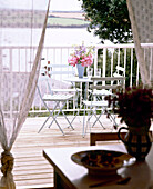 Überdachter Balkon mit gestrichenem Tisch und Stühlen