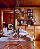 Swiss chalet dining room with wood panelling and table set for meal