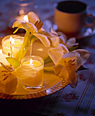 Nahaufnahme von einem Teller mit Teelichtern und Blüten