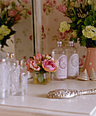 Silver hairbrush and scent bottles on dressing table