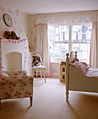 Child's pink bedroom with floral wallpaper and painted bed