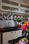 Collection of black and white tableware displayed above kitchen sink unit