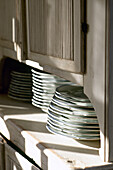 Plates stacked in white wood dresser