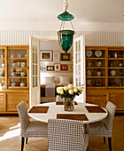 Round table with check pattern chairs in dining room with display units