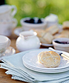 An outside detail of food on a table white plates jug napkins buns