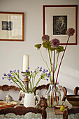 Cut flowers and candles with framed artwork in dining room of Port Issac beach house Cornwall