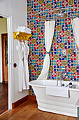 Brightly tiled bathroom with shower curtain and bathrobes Lot et Garonne, France