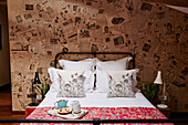 Metal framed bed in room decorated with vintage newspaper Lot et Garonne, France