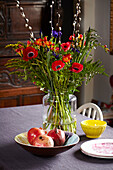 Poppies and pomegranates on table in Brighton home East Sussex, UK