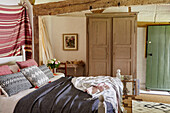 Bedroom in thatched 17th century cottage with painted wardrobe Hampshire, UK