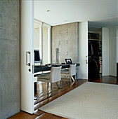 Contemporary open plan dual home office and bedroom space with sliding partition walls and large glass panelled windows