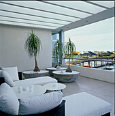 Blick auf den See von einem modernen, luxuriösen Balkon mit Sofas, Stühlen und Polstermöbeln