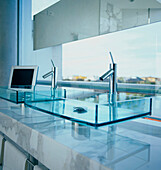 Modernes Badezimmer mit quadratischen Glaswaschbecken und Marmoreinfassung und Blick nach draußen