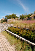 Grey granite stone walls and steps with Gramineae grasses in garden designed by Alejandra de Domenicci