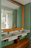 Green panelled bathroom with double basin and cedar wood box