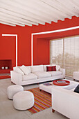 Red living room with polished Portland cement floor and eucalyptus beamed ceiling