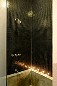 Black tiled shower unit with lit candles